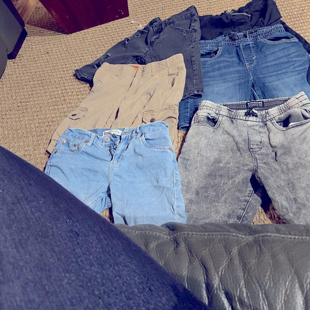 6 pairs of boys short pants. 1 brown, 2 black, 2 blue and 1 gray.